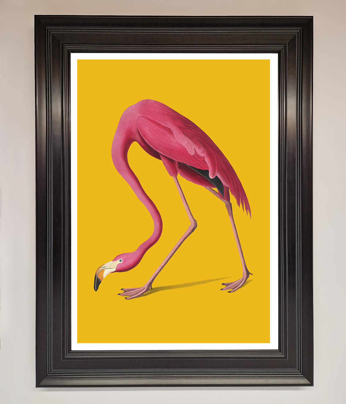 Pink Flamingo on Yellow Framed Print in elegant black frame.